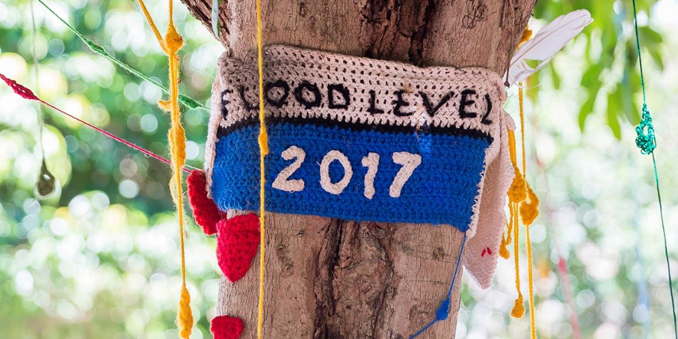 Close up of a trunk with knitted sign around that reads flood level 2017 