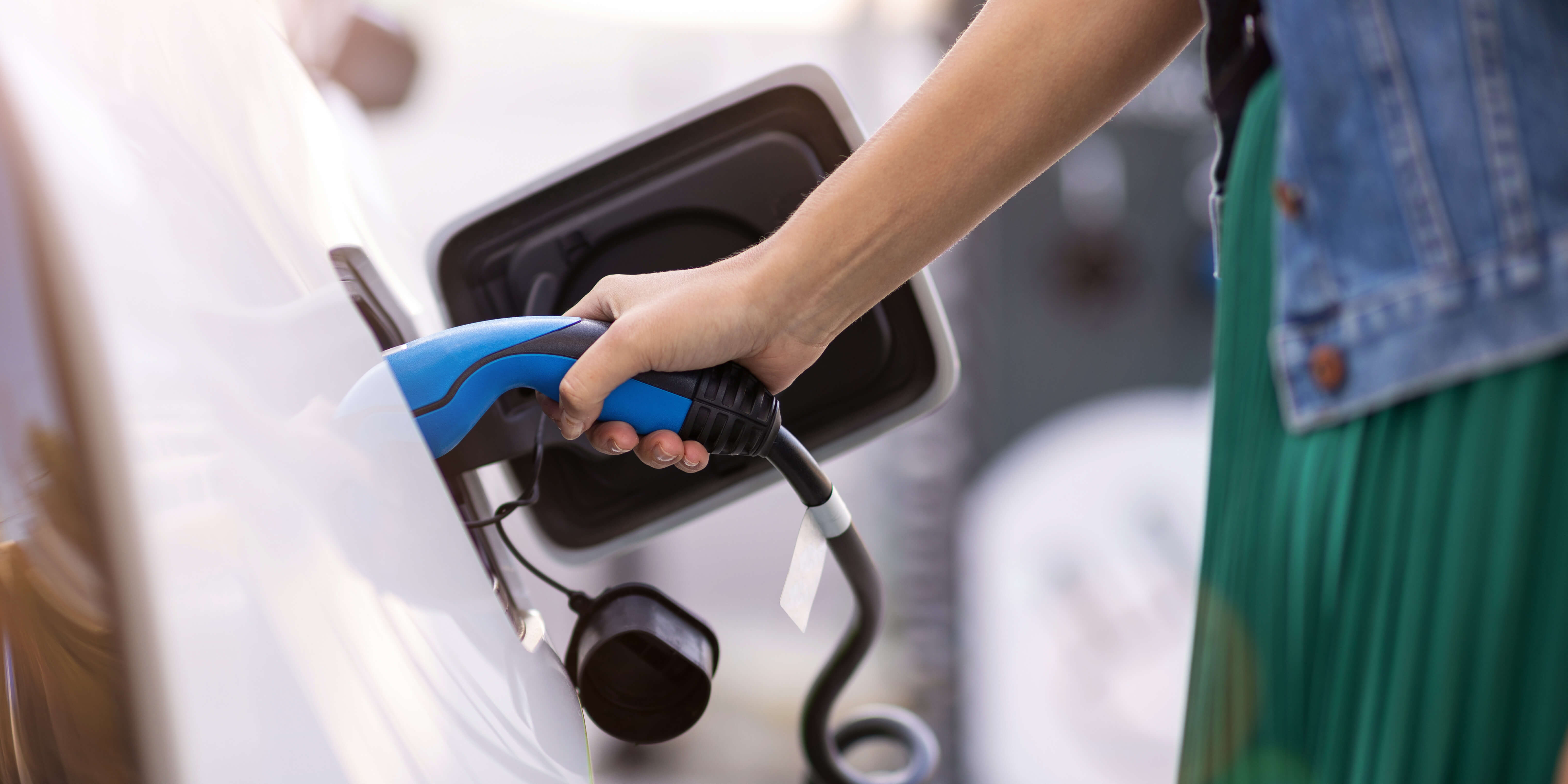 Close up of a woman charging an electric vehicle