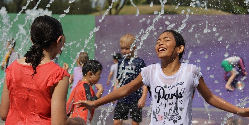 Children playing in water fountain on a hot day