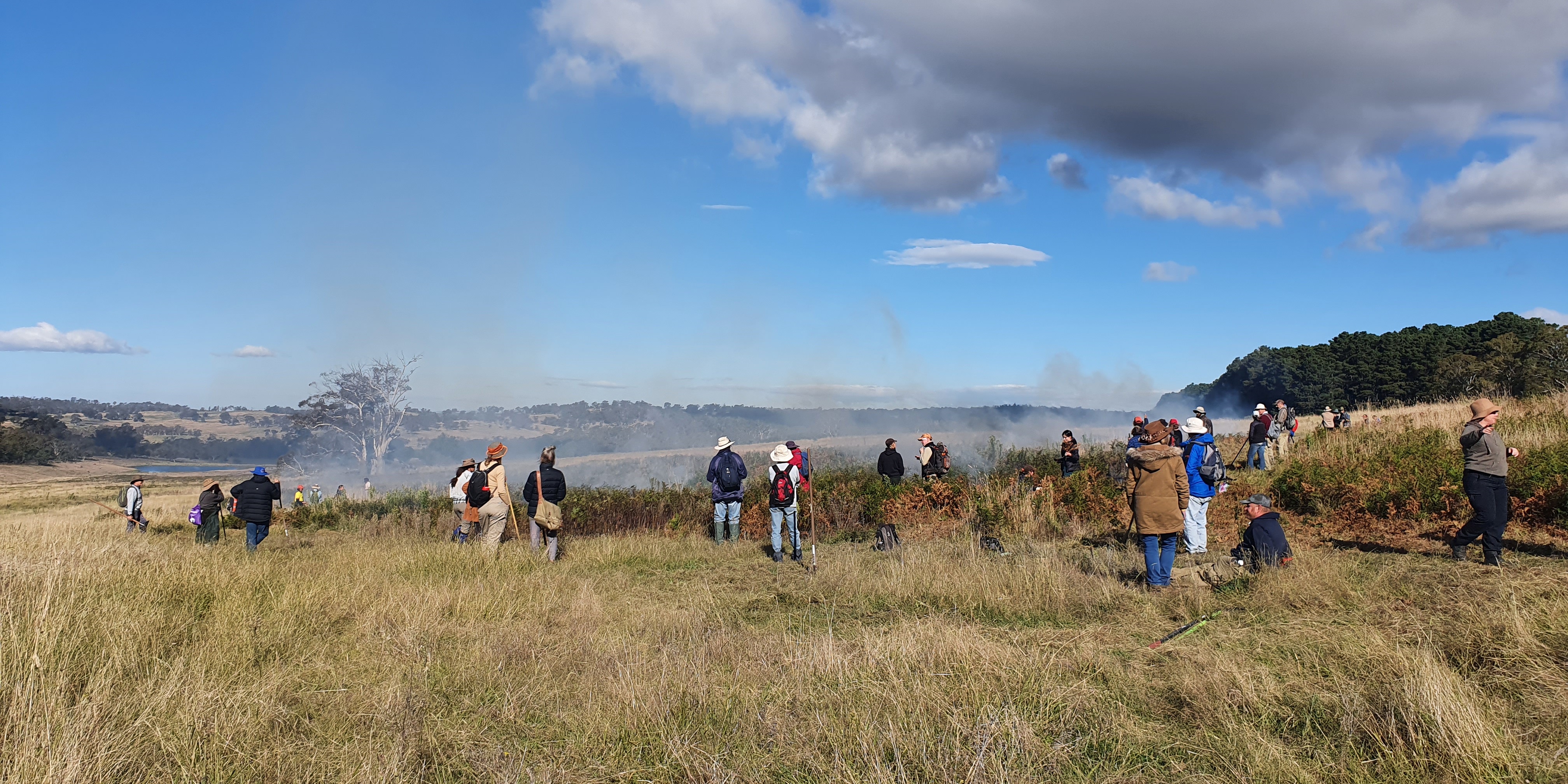 People in a field watching a controlled burn