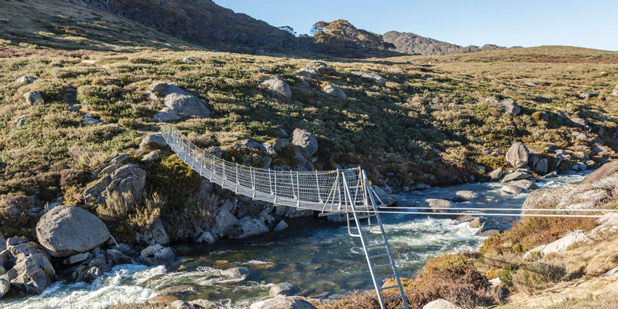 A small walking bridge over a river in the snowy mountains, NSW
