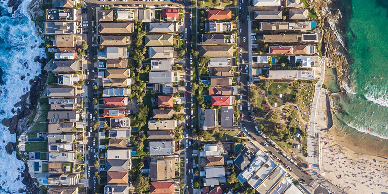 Aerial view of houses built on a cliff close to the ocean