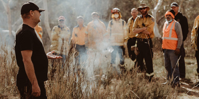 A Fire Practitioner leading a group in a discussion on traditional burning techniques