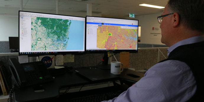 NSW Senior Project Officer reviews climate maps on computer