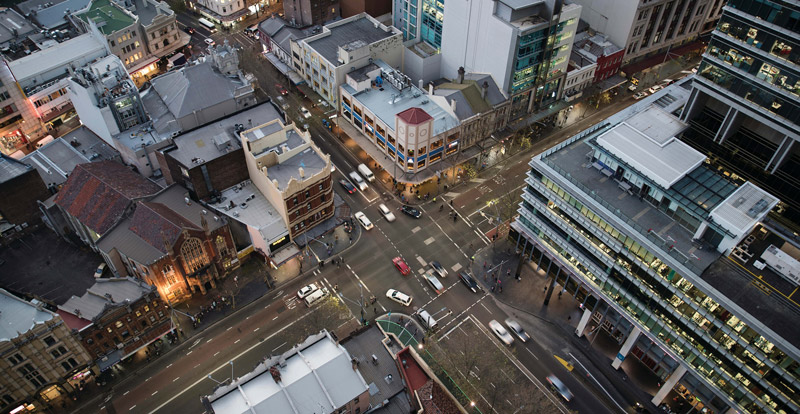 Aerial Sydney cityscape at dusk including office buildings a church and streets.