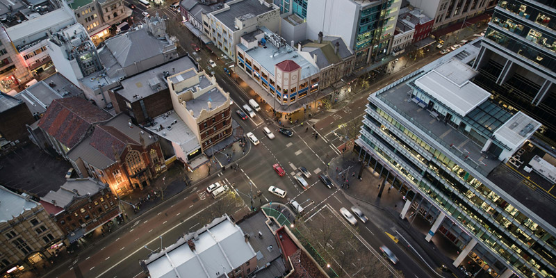 Aerial Sydney cityscape at dusk including office buildings a church and streets