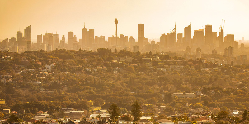 Sydney central business distract in the background with the suburbs in the foreground. Orange tones due to heat 