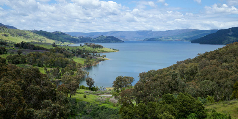 a blue lake surrounded by green rolling hills