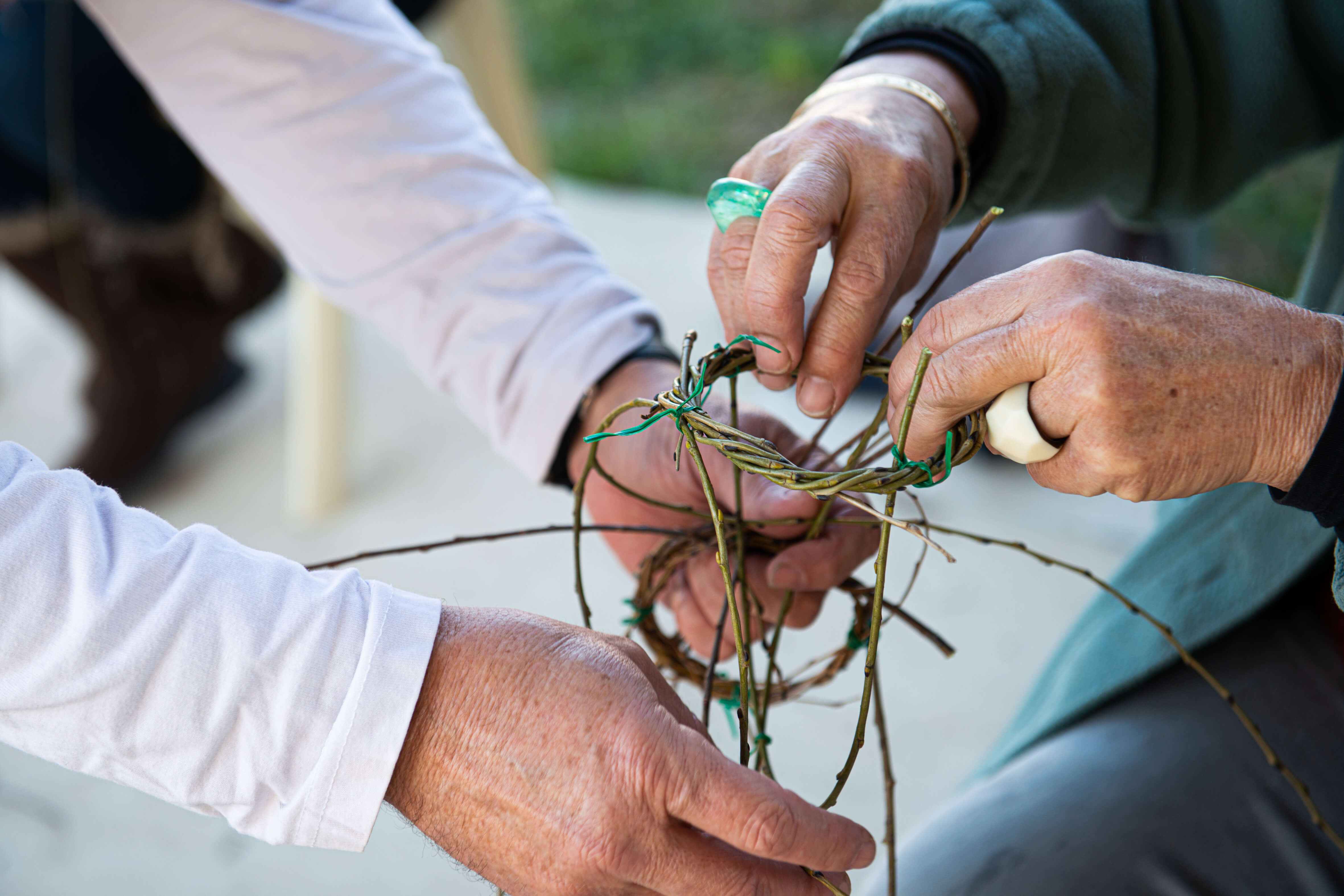 Close up of hands weaving grass