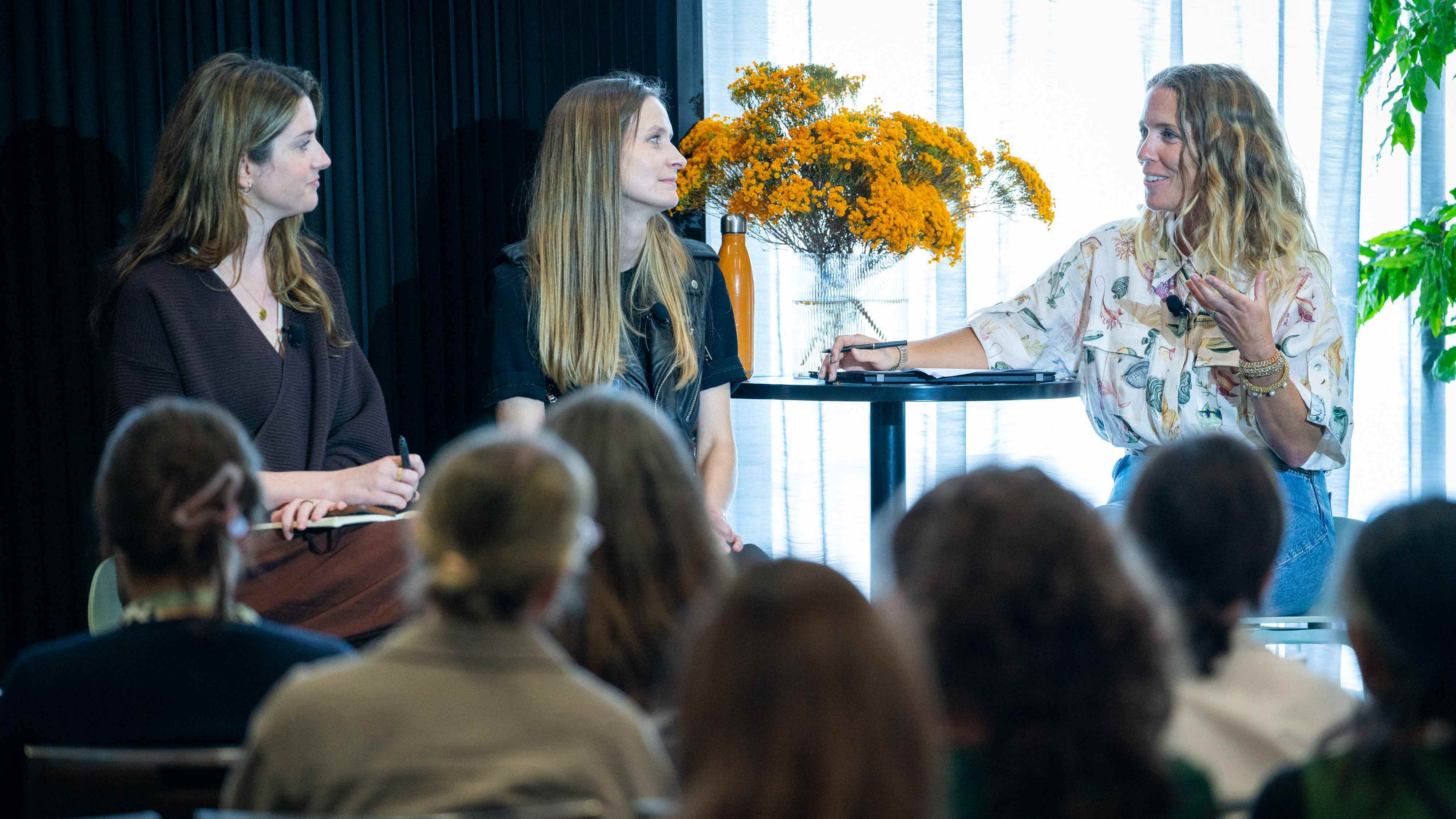 A group of three people sitting in a row, part of a panel discussion at the AdaptNSW 2023 Forum.2023