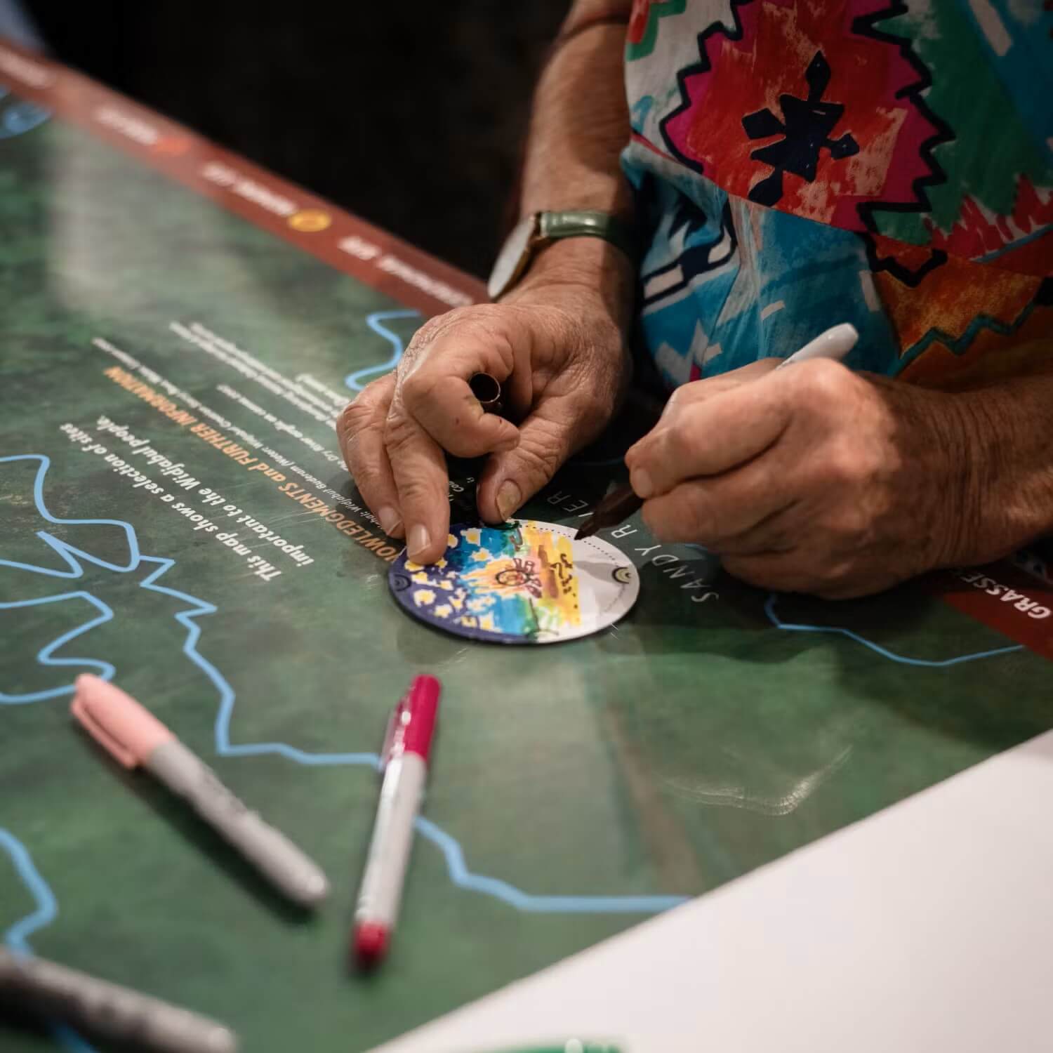 Image of women creating art on a small circle of paper