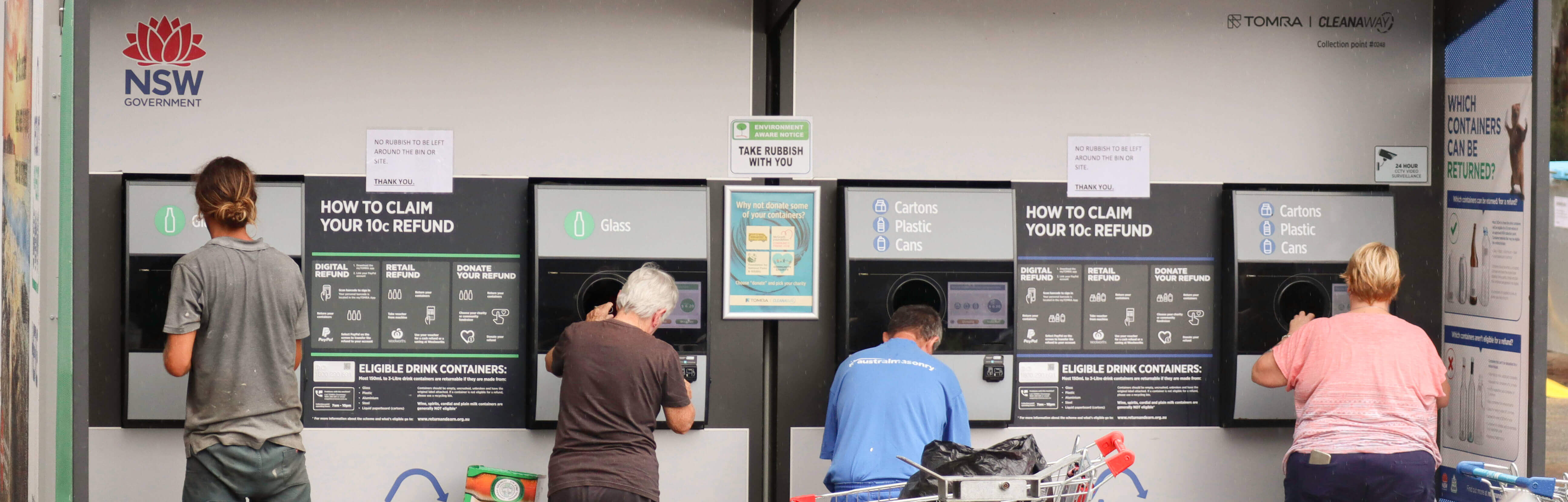4 persons backside using a Return and Earn Reverse vending machine 