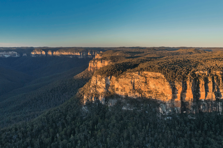 Morning light coming over the rocky escarpments of the Grose Valley, Blue Mountains National Park. 