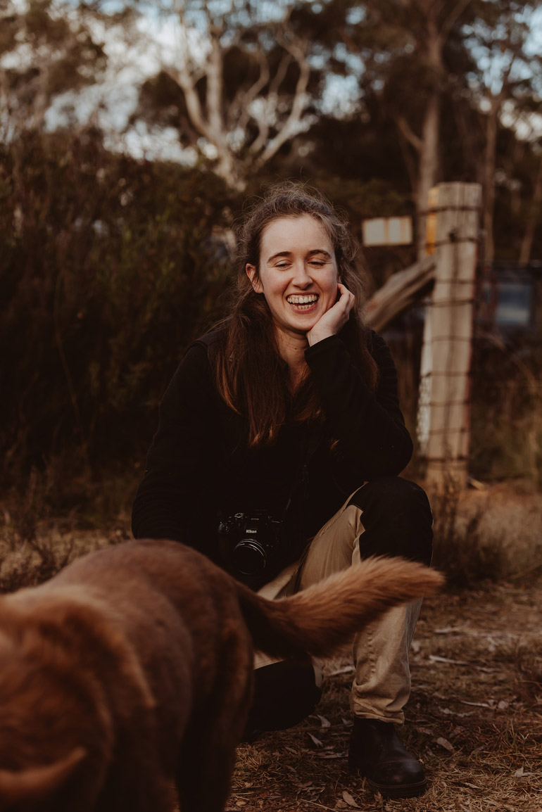 woman crouching down with dog