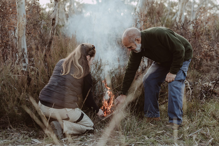 man and woman crouching down in the bush