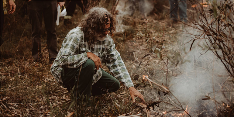 Fire Practitioner demonstrating how to spark up a patch of native forbs and grasses