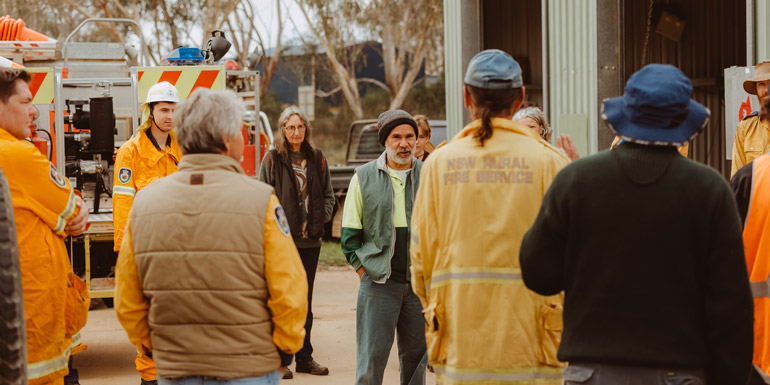 Group of people standing around next to a fire truck