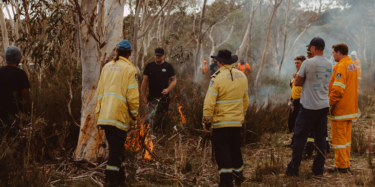 people standing around in the bush cool burning